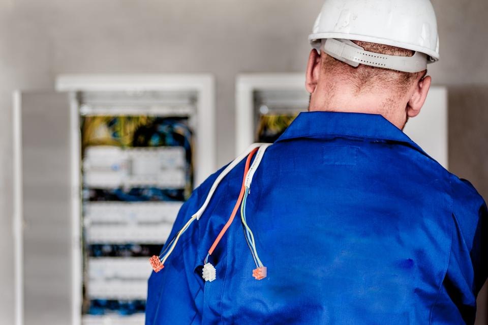 Technik v ochranné přilbě u rozvodných skříní